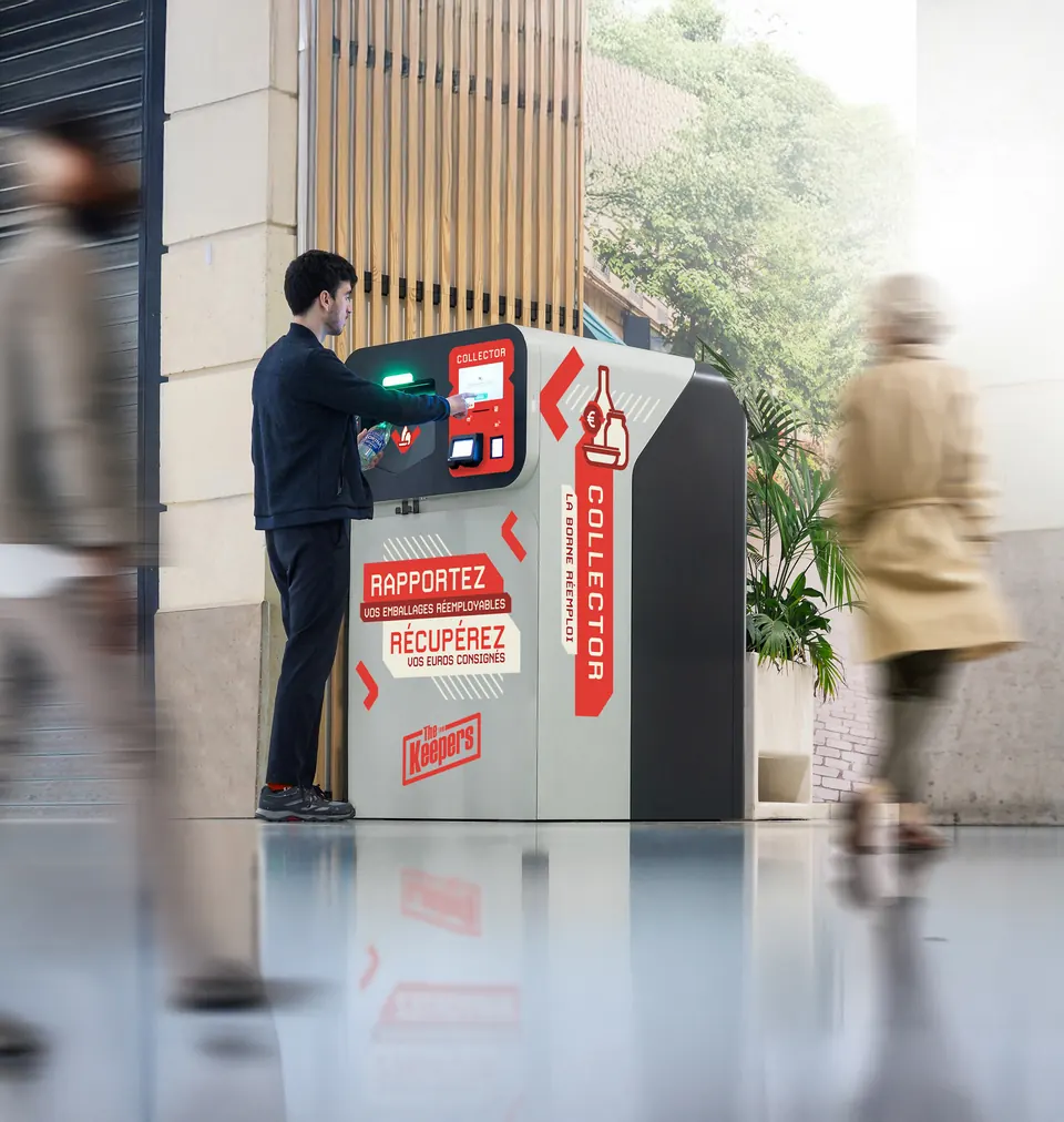 A customer returns reusable packaging into the Collector, a reverse vending machine installed at a store entrance