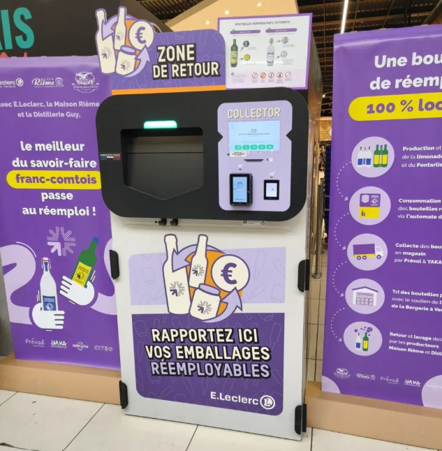 El Collector del E.Leclerc de Pontarlier en la zona de devolución, con carteles sobre la reutilización local