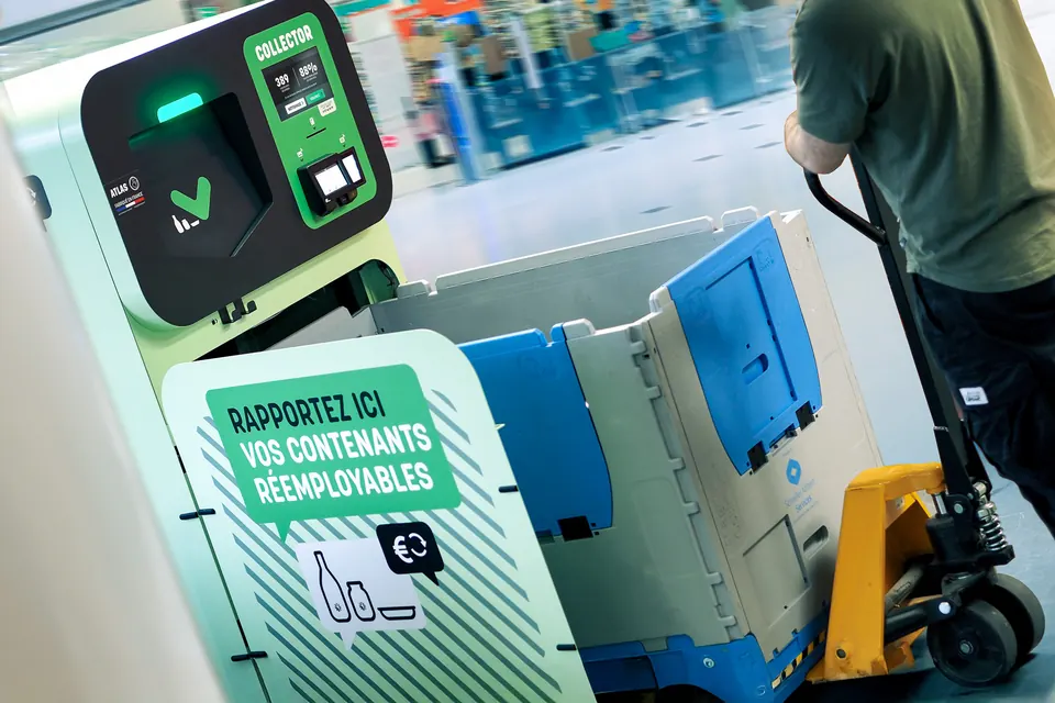 Un employé sort la caisse-palette pleine au transpalette